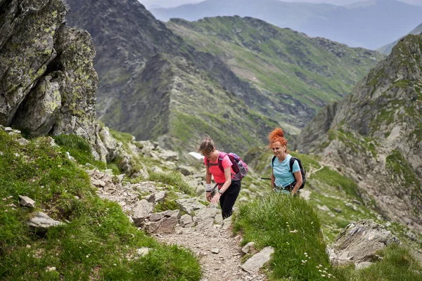 Duas Mulheres Caminhantes Com Mochilas Caminhando Uma Trilha Nas Montanhas — Fotografia de Stock