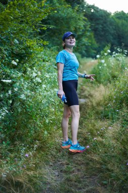 Kadın koşucu ormanda yolda koşuyor