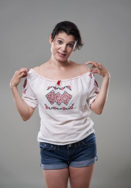 Gri arka planda günlük giysiler içindeki esmer kadını cezbediyor.