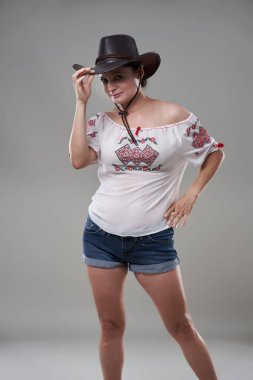 Gri arka planda günlük giysiler içindeki esmer kadını cezbediyor.