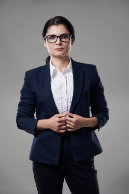 Gri arka planda yoğun bir görüntüsü olan bir iş kadınının yakın çekimi.