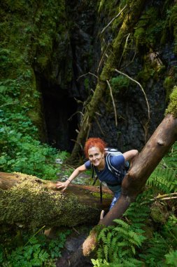 Sırt çantalı bir kadın bir mağarayı keşfediyor. 