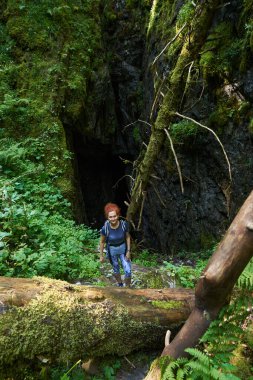 Sırt çantalı bir kadın bir mağarayı keşfediyor. 