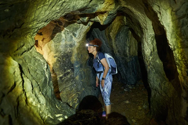 Sırt çantalı bir kadın bir mağarayı keşfediyor. 
