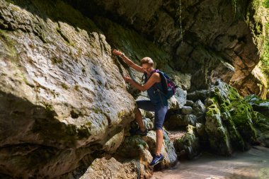Sırt çantalı bir kadın, içinde nehir olan güzel bir vadiyi keşfediyor.