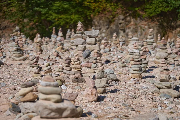 River pebbles and stones arranged in tower structures on the shore