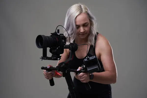 Gri Arka Planda Sinema Kamerası Olan Kadın Kameraman — Stok fotoğraf