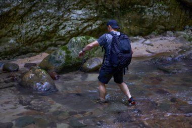 Sırt çantalı profesyonel doğa fotoğrafçısı bir vadide fotoğraf çekiyor.