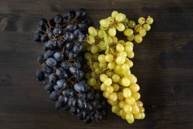 Koyu mavi ve sarı çekirdeksiz üzümler kırsal bir tahta üzerinde