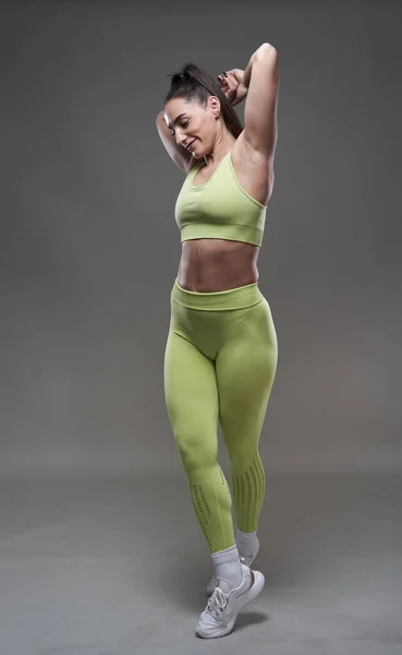 Attraktiv Hispanic Fitness Modell Poserar Gym Klädsel Grå Bakgrund — Stockfoto
