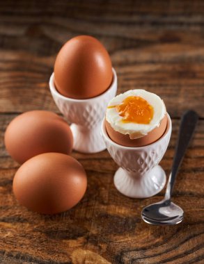Tahta bir tahtanın üzerinde, yumurta kabında kaynamış yumurta, görülebilir cıvık yumurta.
