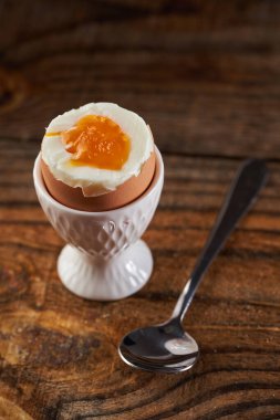 Tahta bir tahtanın üzerinde, yumurta kabında kaynamış yumurta, görülebilir cıvık yumurta.
