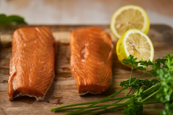 Smoked salmon fillet steaks on a wooden board in closeup