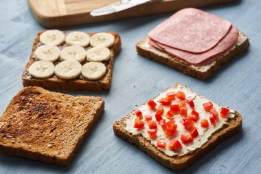 Kahvaltı için salamlı, çikolatalı ve muzlu, krem peynirli ve kırmızı biberli sandviçler.