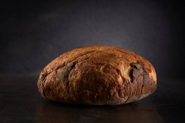 Koyu bir ahşap tahtada ev yapımı tahıllı ekmek.