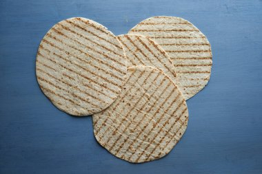 Düz tortilla ambalajı, ahşap bir mavi tahta üzerinde izole bir şekilde duruyordu.