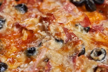 Eritilmiş parmesanlı, zeytin, pepperoni ya da jambon gibi içerikli bir pizzanın üzerine Macro shot.