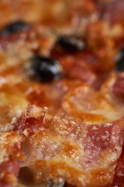 Eritilmiş parmesanlı, zeytin, pepperoni ya da jambon gibi içerikli bir pizzanın üzerine Macro shot.