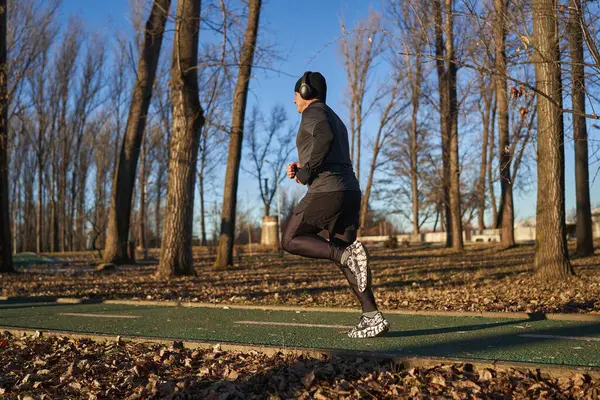 寒い晴れた冬の日に公園で走る成熟したアスリート — ストック写真