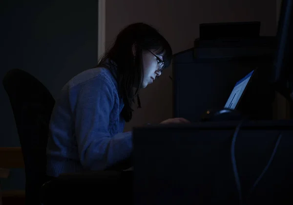 ソフトウェア開発者女性 彼女の机で彼女のラップトップで夜遅く働いています — ストック写真