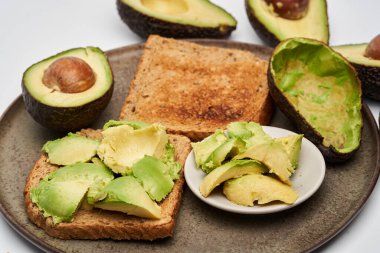 Beyaz arka planda izole edilmiş tostlarda taze avokado yakın plan.