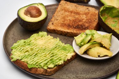 Beyaz arka planda izole edilmiş tostlarda taze avokado yakın plan.