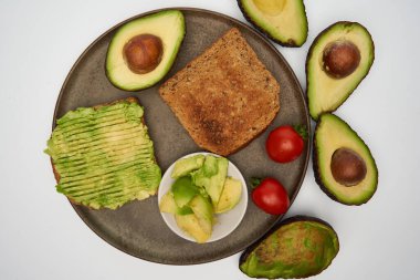 Beyaz arka planda izole edilmiş tostlarda taze avokado yakın plan.