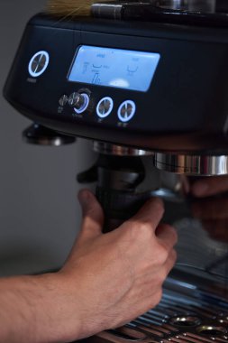 Erkek barmen, yüksek kaliteli kahve espresso yapmak için profesyonel aletler kullanıyor.