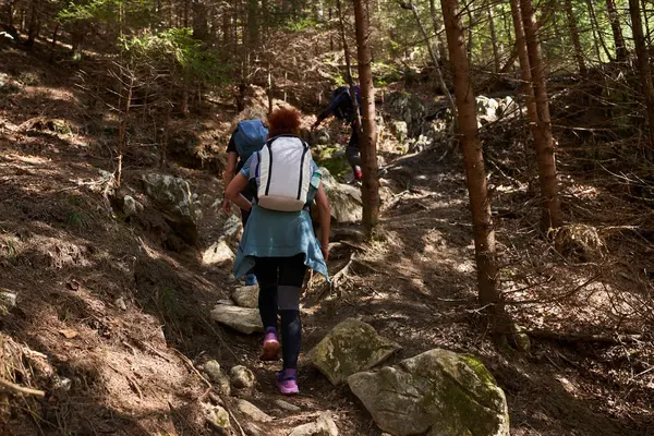 两个背着背包在山路上远足的女徒步旅行者 图库图片