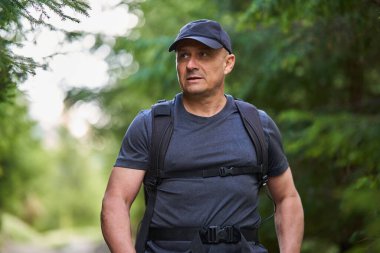 Yaz başında dağlarda yürüyüş parkurunda sırt çantalı bir yürüyüşçü.