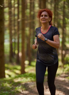 Kızıl saçlı kadın, ormanda koşucu eğitimi alıyor.