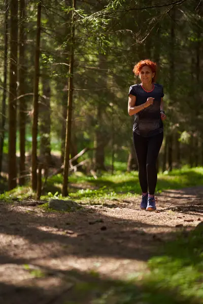 Redhead Woman Trail Runner Training Forest Running Uphill Stock Photo