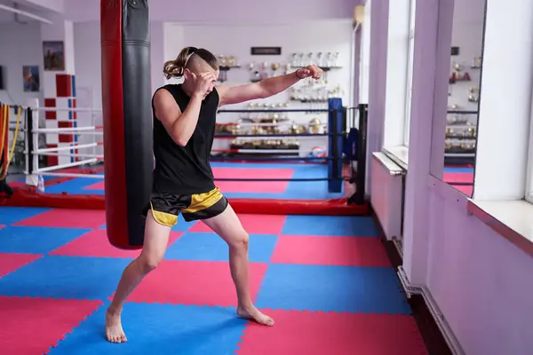 stock image Young teenage kickbox fighter doing shadow boxing drills in a gym as warm up