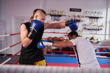 Profesyonel kickboks antrenörü ve boksör ringde dövüşüyor.