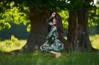 Ormanda yeşil elbiseli İspanyol güzellik modeli  