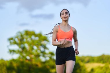 İspanyol kız ormanda bir patikada koşuyor.