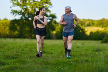 Spor yapan insanlar orman yolunda kolay bir koşuya çıkıyorlar.