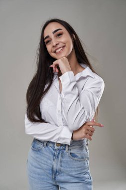 Gri arka planda düşünceli bir İspanyol iş kadınının yakın çekimi.