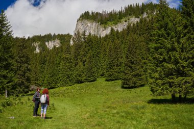 Sırt çantalı kadın yürüyüşçüler dağlarda yürüyüş parkurları, aktif tatil konsepti