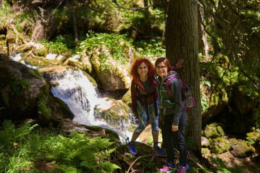 Sırt çantalı kadın yürüyüşçüler dağlarda yürüyüş parkurları, aktif tatil konsepti