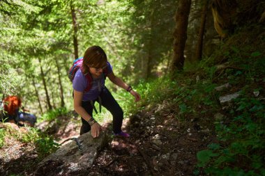 Sırt çantalı kadın yürüyüşçüler gündüz dağlarda yürüyüş parkurunda
