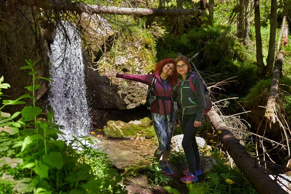 Sırt çantalı kadın yürüyüşçüler dağlarda yürüyüş parkurları, aktif tatil konsepti