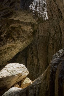 Yazın kireçtaşı dağlarında bir mağara girişi.