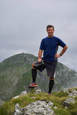 Uzun ve yorucu bir yürüyüşten sonra kamera ve yüksek dağlarla bir turist.