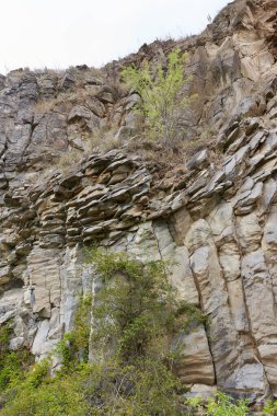 Various rocks of basalt, sandstone and dross in layers in abandoned quarry clipart