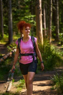 Kızıl saçlı yürüyüşçü dağlarda gündüz vakti ormanda