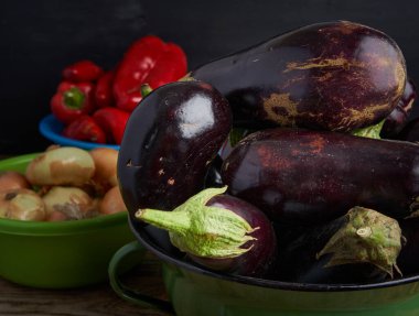 Köy tahtasında çiğ organik patlıcan, kırmızı biber ve soğan.