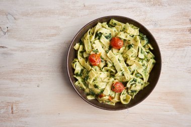 Peynirli makarna soslu makarna, ıspanak ve kiraz domatesli köy tahtası.