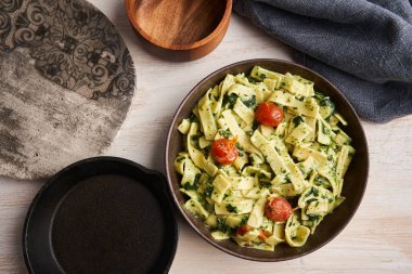 Peynirli makarna soslu makarna, ıspanak ve kiraz domatesli köy tahtası.