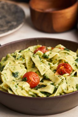 Peynirli makarna soslu makarna, ıspanak ve kiraz domatesli köy tahtası.